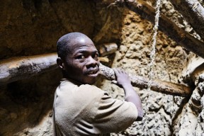 Sur le site de la mine de Kola au Mali, un Kaladian Tigui, (celui qui porte le Kaladian, petite pioche en Bambara) redescend dans le puit à l'intérieur duquel il vient de creuser plusieurs heures à la recherche d'or. Au printemps 2008, dans une forêt a quelques kilomètres de la ville de Bougouni, sur la commune de Kola, un filon aurifère a été découvert. En quelques semaines, des milliers de personnes, des familles entières, hommes femmes et enfants, venus des villes et des pays voisins, se sont installés sur le site. Coupée a la machette, la forêt a peu a peu laissé place a une petite ville, le "Bougoufié» ou poussent les unes contre les autres de petites huttes de plastiques et de paille. Dans cet apparent chaos, une veritable organisation sociale et economique a pris place avec ses chefs, ses règles, ses réseaux et ses métiers. Les Kaladian Tigui affluent de toutes parts ( Sierra Leone, Sénégal, Guinée, Côte d'Ivoire¦). Armes de leur Kaladian, de sacs de tissus et de quelques mètres de cordes pour évacuer les pierres, ils s'enfoncent sous terre. Dans ces profonds boyaux, ou règne une chaleur moite et suffocante, ils cognent du lever du jour au coucher du soleil à la cherche de la pepite ou des quelques grammes d'or qui les feront sortir de leur dénuement. Kola, MALI - décembre 2008.